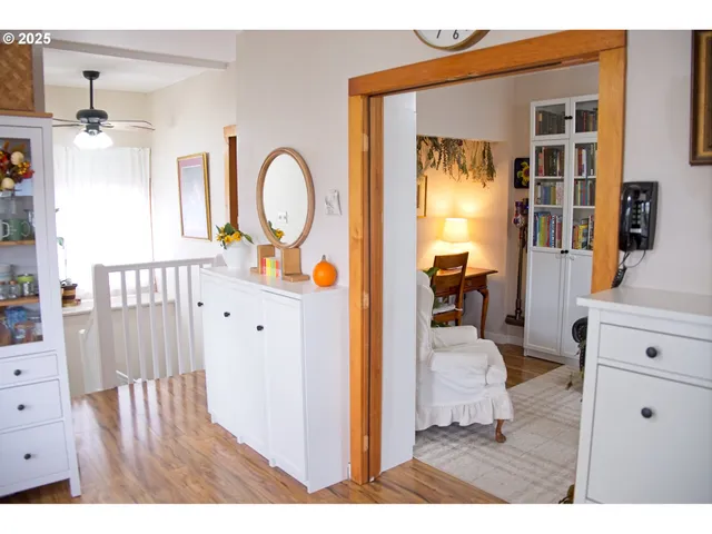 a hallway with a large kitchen view of living room and wooden floor