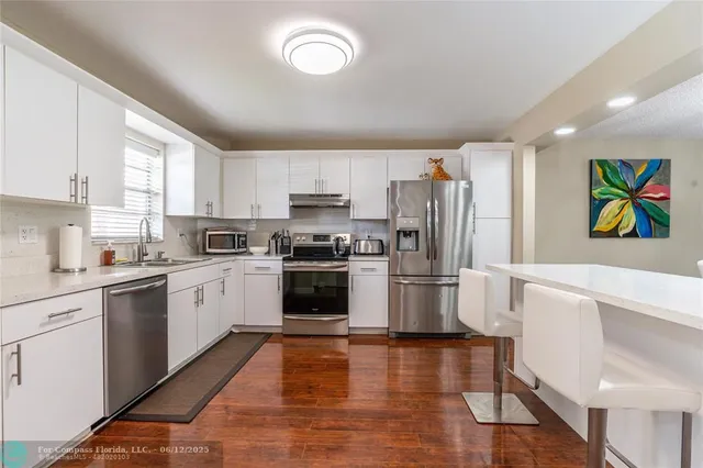 a view of a dining room with furniture a chandelier and wooden floor