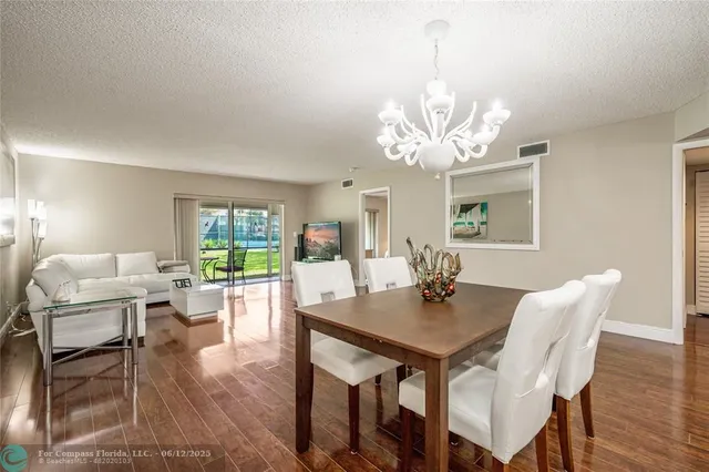 a bedroom with a large bed a flat tv screen and chandelier