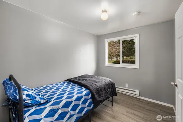 a bedroom with a bed and wooden floor