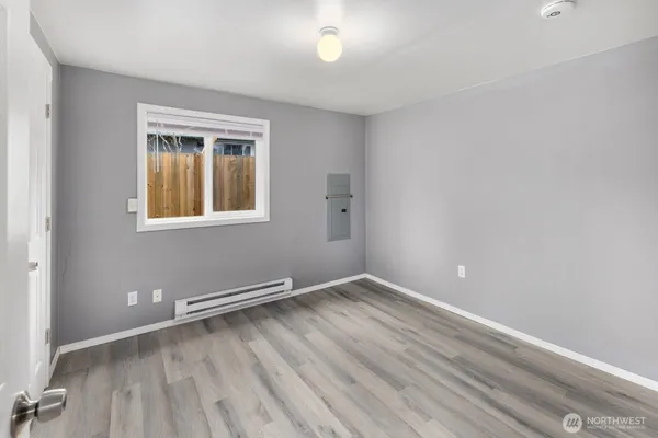 an empty room with wooden floor and windows