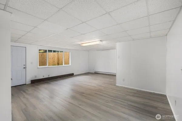 a view of a room with wooden floors and white walls