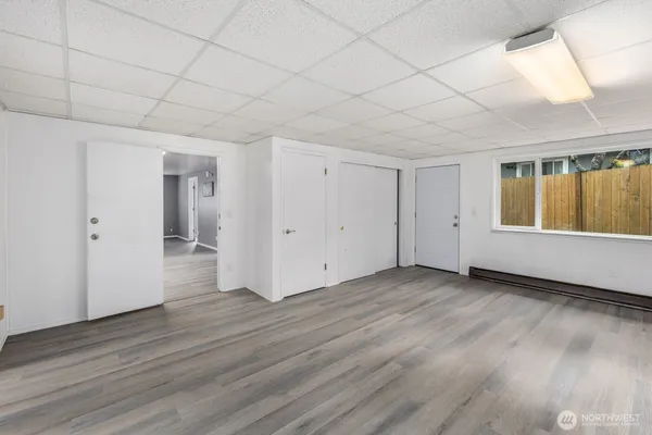 an empty room with wooden floor and windows