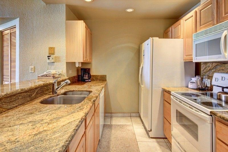 3445 Lower Honoapiilani Road, Unit 255 Lahaina, HI 96761 - Photo 10 of 35 a kitchen with granite countertop a sink and a refrigerator