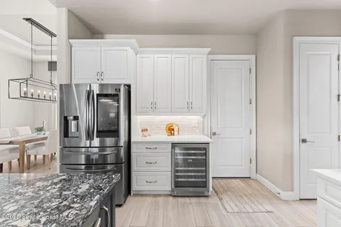a kitchen with stainless steel appliances kitchen island granite countertop a refrigerator and cabinets