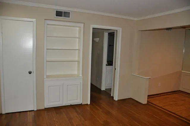 a view of an empty room with closet and a window