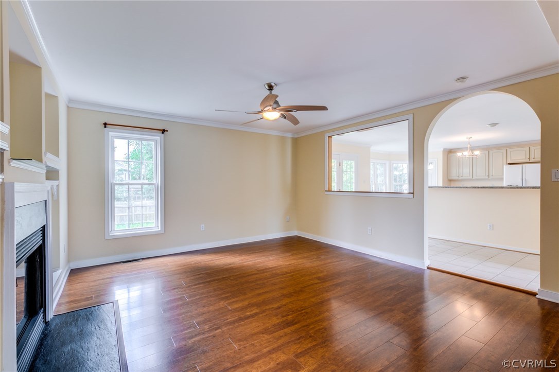 9601 Dunroming Road Chesterfield, VA 23832 - Photo 13 of 34 an empty room with wooden floor chandelier and fireplace