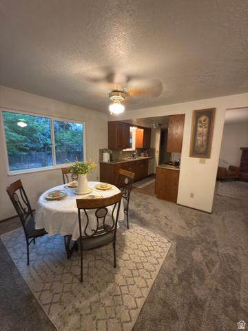 1164 East Mountain Road Logan, UT 84321 - Photo 39 of 45 Dining area featuring carpet flooring, a large window, and a ceiling fan with integrated lighting