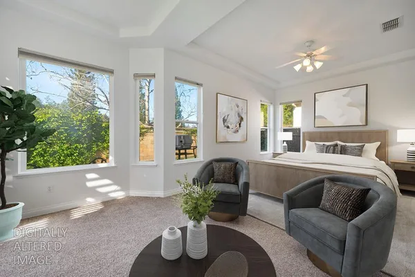 a bedroom with furniture and a large window