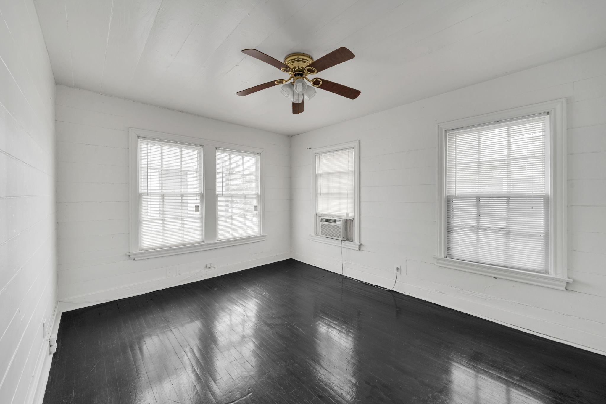 1947 Richmond Avenue, Unit B Houston, TX 77098 - Photo 3 of 12 an empty room with wooden floor fan and windows