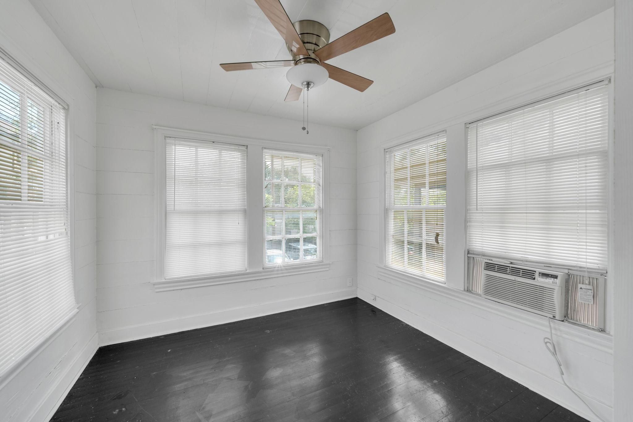 1947 Richmond Avenue, Unit B Houston, TX 77098 - Photo 8 of 12 a view of an empty room with a window and wooden floor