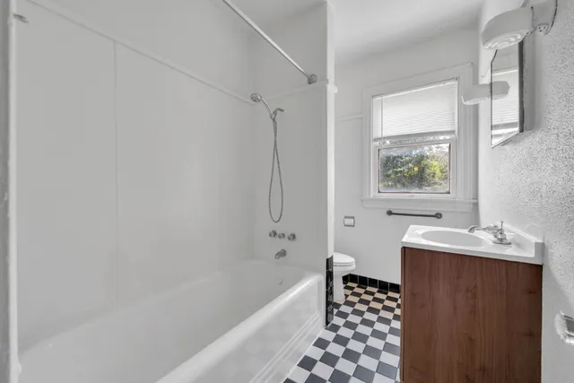 a bathroom with a bathtub sink and mirror
