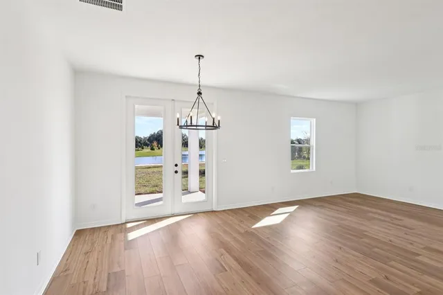 a view of empty room with wooden floor and window