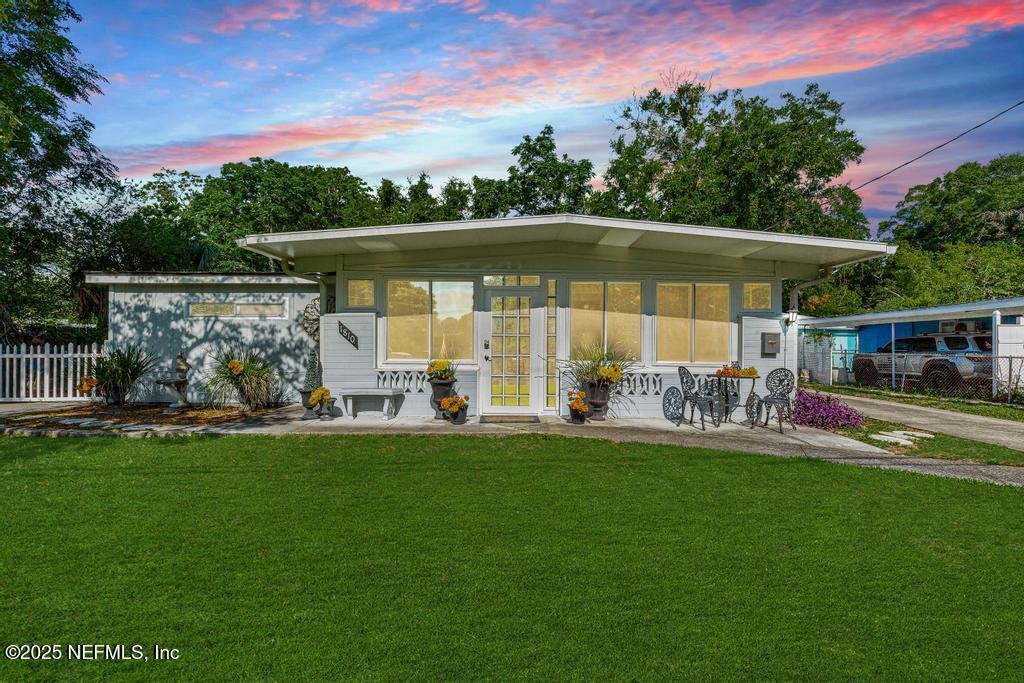 1810 Griflet Road Jacksonville, FL 32211 - Photo 1 of 42 a view of a swimming pool with a table and chairs under an umbrella