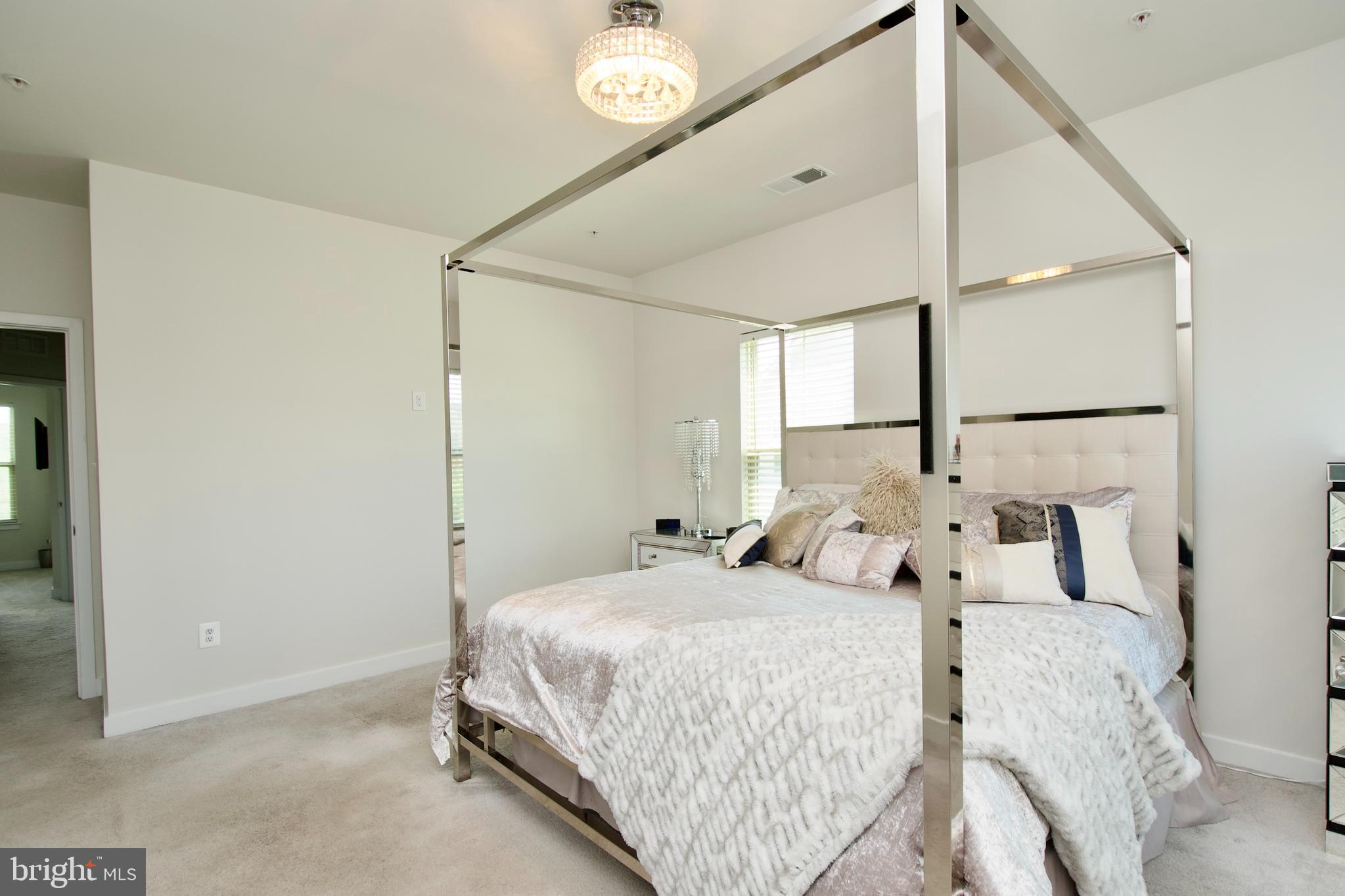 10810 Norbourne Farm Road Upper Marlboro, MD 20772 - Photo 17 of 38 a bedroom with a large bed and a chandelier