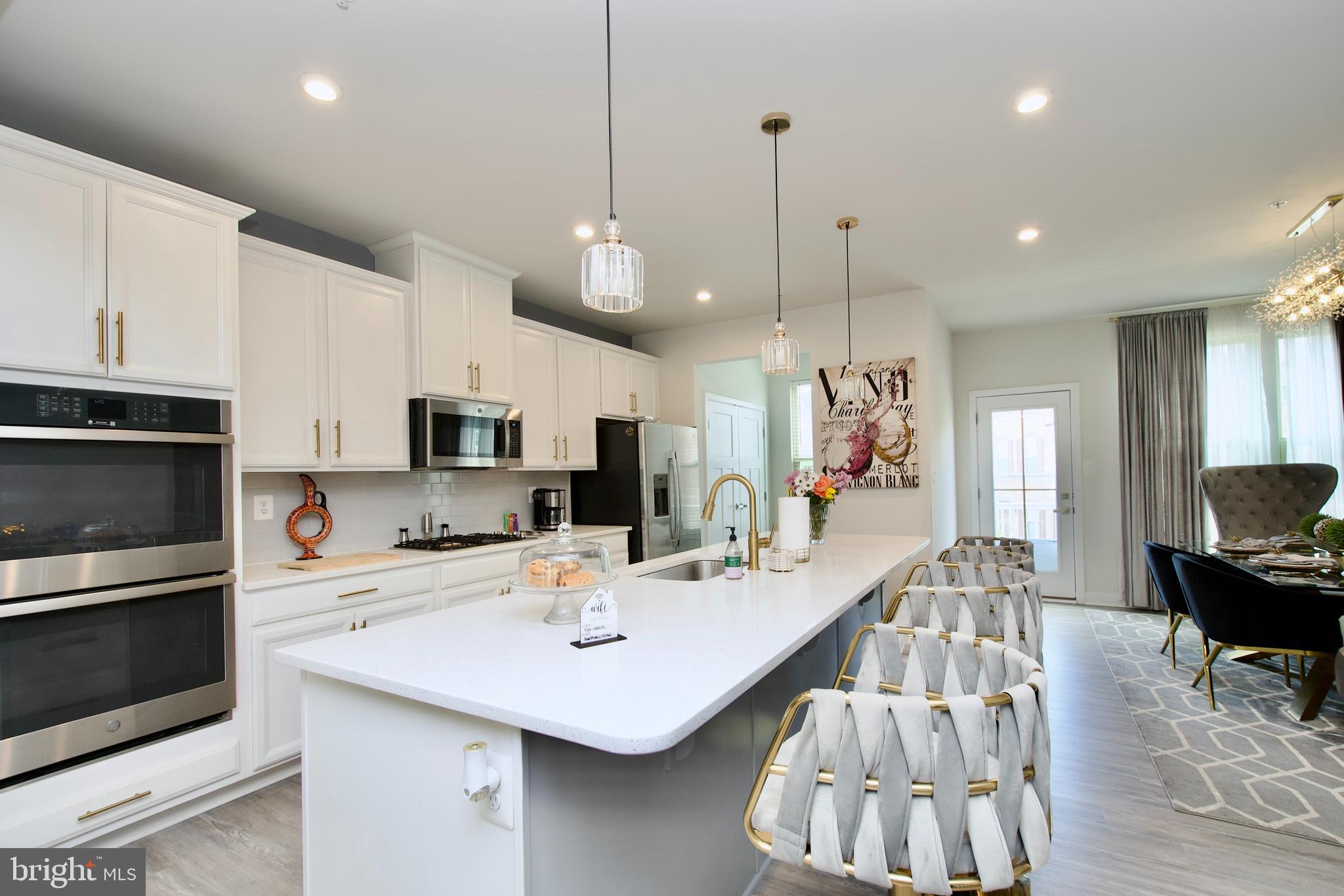 10810 Norbourne Farm Road Upper Marlboro, MD 20772 - Photo 7 of 38 a kitchen with stainless steel appliances kitchen island granite countertop a stove a sink a microwave a center island and furniture