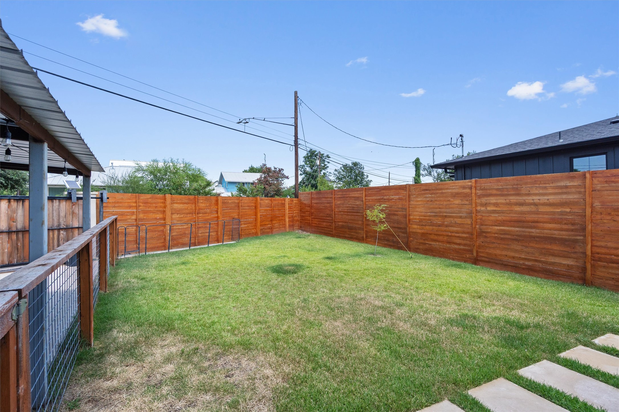 1147 Webberville Road Austin, TX 78721 - Photo 26 of 37 A neatly fenced private yard with vibrant green grass offers a secluded outdoor retreat.