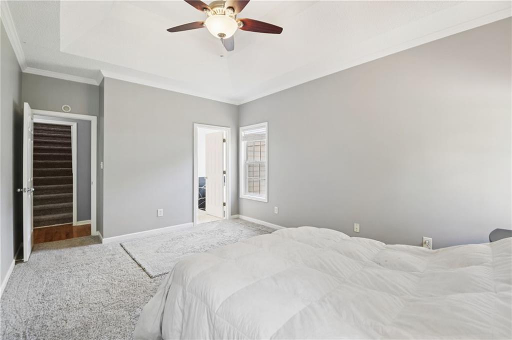 173 Freeman Forest Drive Newnan, GA 30265 - Photo 14 of 35 a bedroom with a large bed and a chandelier