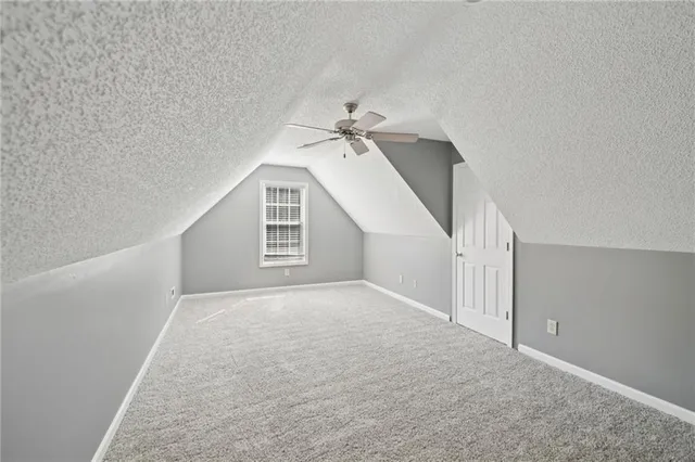 an empty room with a ceiling fan and a window