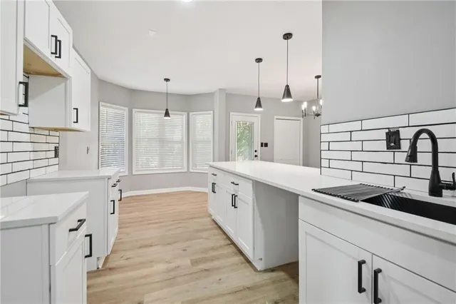 a view of kitchen with stainless steel appliances granite countertop cabinets and chandelier