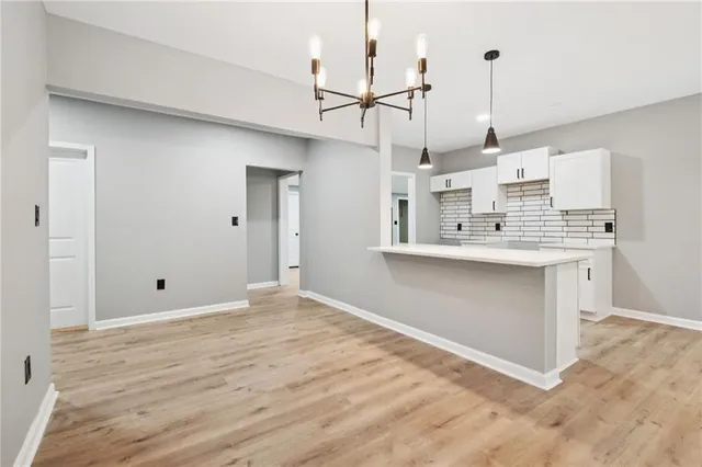 a view of an empty room and kitchen view