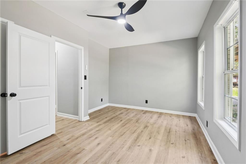 173 Freeman Forest Drive Newnan, GA 30265 - Photo 31 of 35 an empty room with wooden floor cabinet and windows
