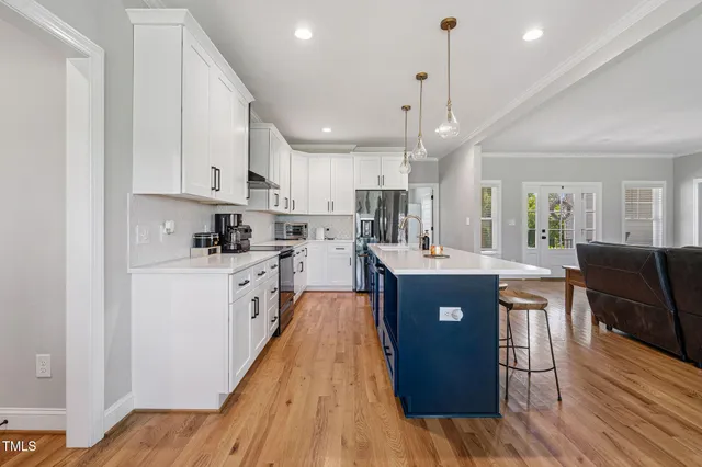 a large kitchen with lots of counter space a sink appliances and cabinets