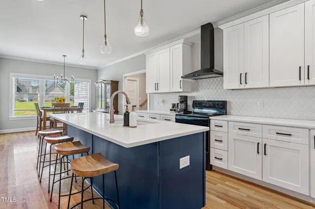 a kitchen with stainless steel appliances kitchen island granite countertop a sink a stove a table and chairs