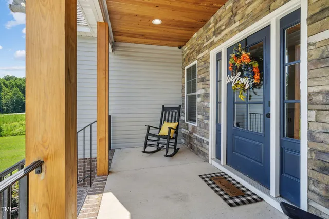 a view of a porch with a table and chairs