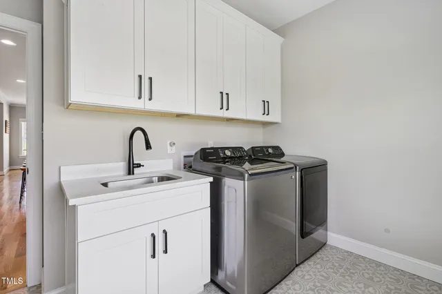 a utility room with sink dryer and washer