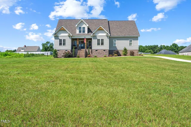 a front view of a house with a yard and potted plants