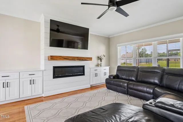 a living room with furniture a flat screen tv and a fireplace