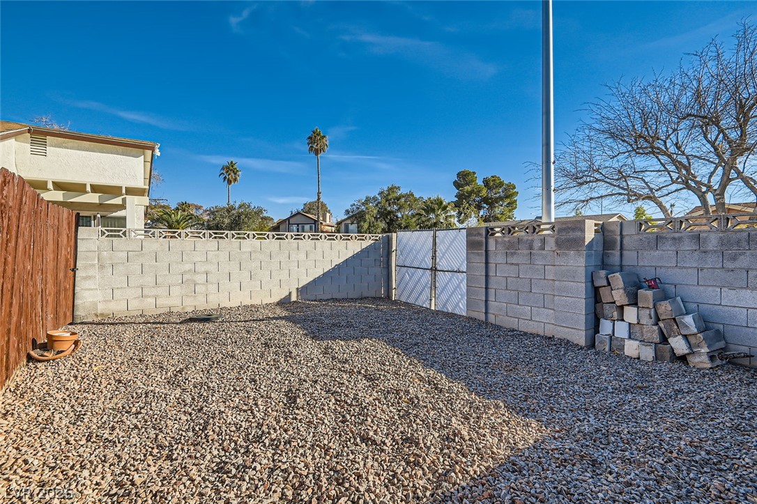 3665 Bronco Road Las Vegas, NV 89103 - Photo 27 of 28 Gravel covers this private yard, framed by sturdy block and wood fencing.