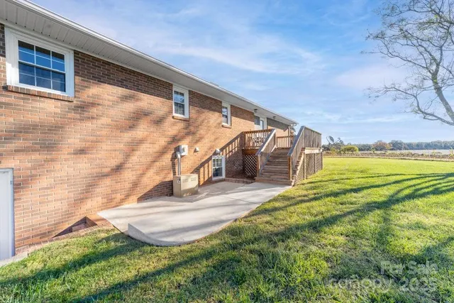 a view of a big house with a big yard and large trees