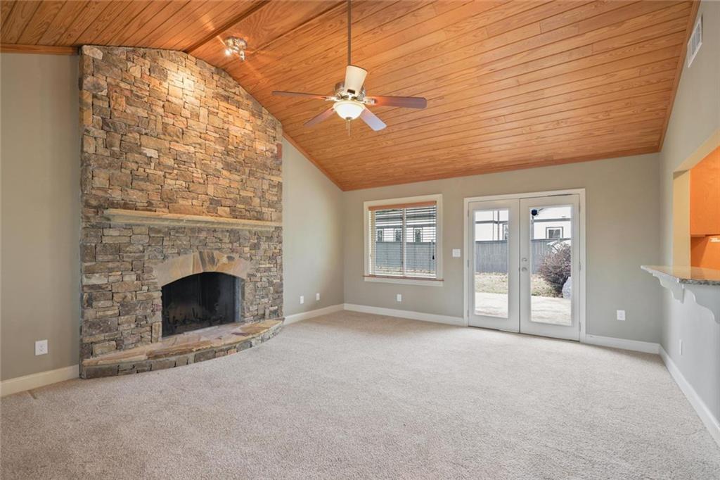 a view of an empty room with a fireplace and a window