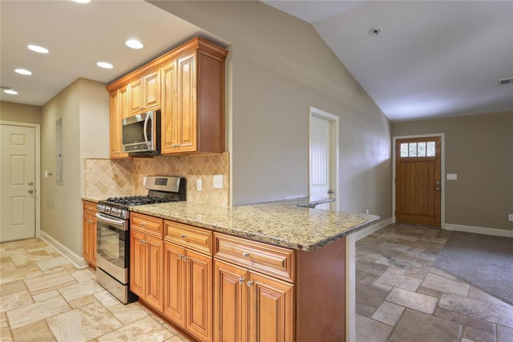 3851 Trickum Road Marietta, GA 30066 - Photo 11 of 27 a kitchen with stainless steel appliances granite countertop a stove and a sink
