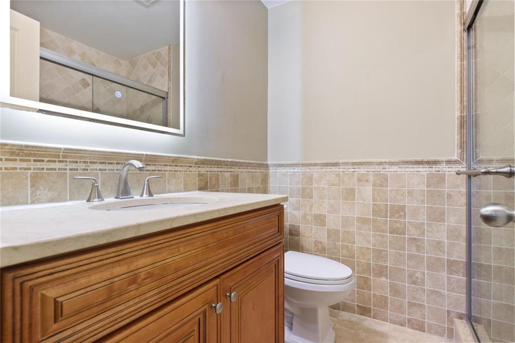 3851 Trickum Road Marietta, GA 30066 - Photo 19 of 27 a bathroom with a sink a toilet and a mirror