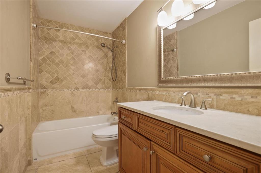 3851 Trickum Road Marietta, GA 30066 - Photo 22 of 27 a bathroom with a granite countertop sink a toilet and shower