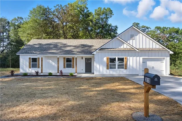 a front view of a house with a garden and yard