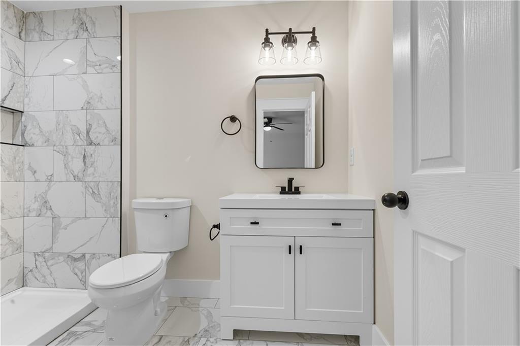 5818 Eastside Drive Austell, GA 30168 - Photo 18 of 39 a bathroom with a toilet a sink a mirror and vanity