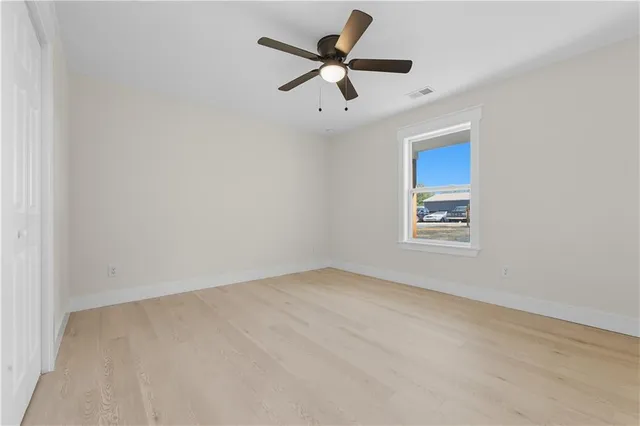 an empty room with a window and a ceiling fan