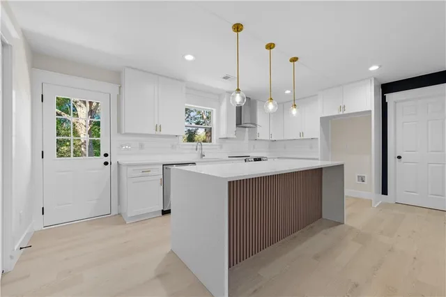 a kitchen with kitchen island a sink a center island a stove and a window