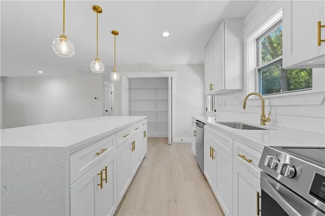 a kitchen with sink stove and cabinets
