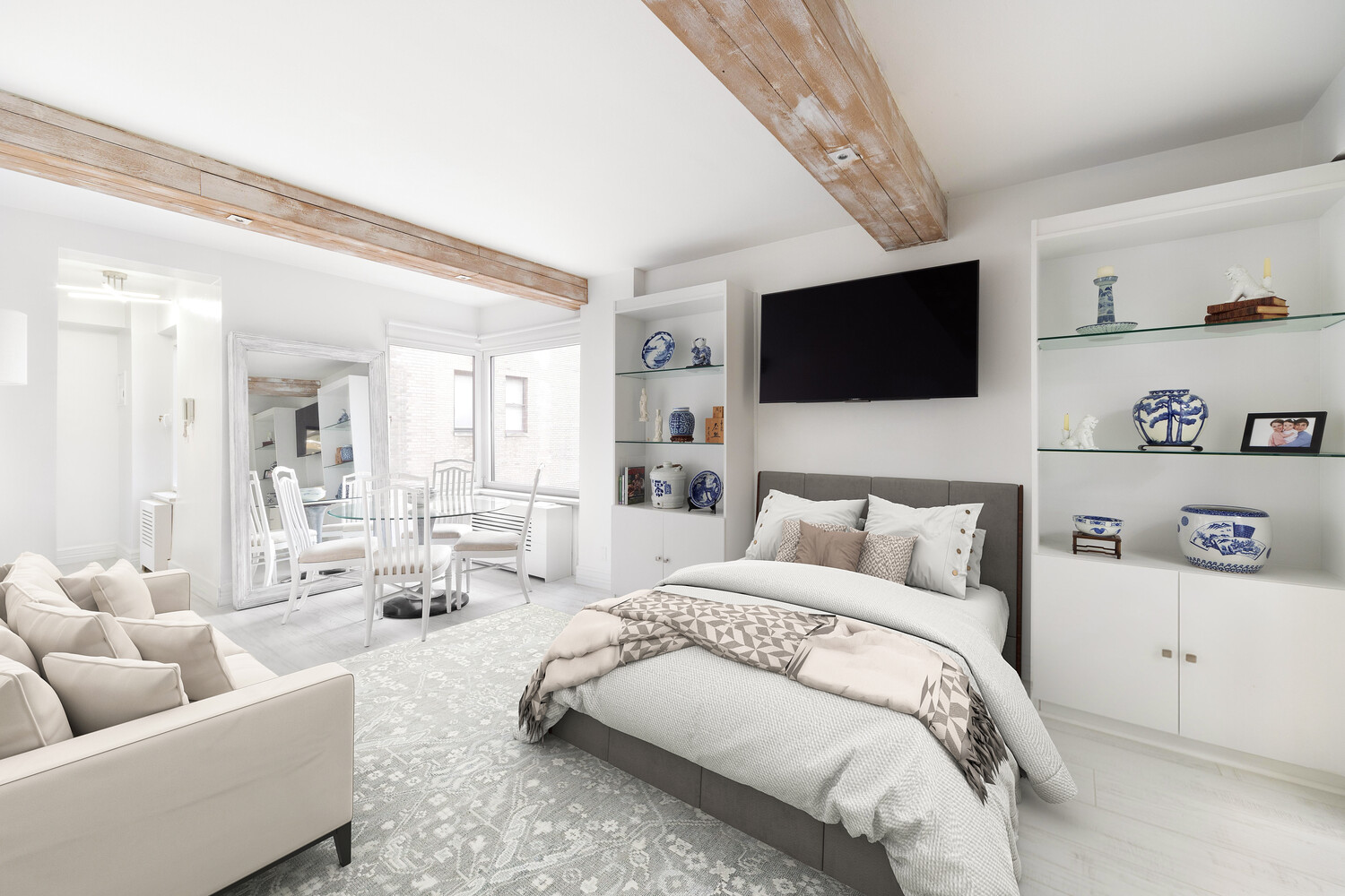 750 Park Avenue, Unit 16D Manhattan, NY 10021 - Photo 4 of 7 a spacious bedroom with a bed a couch and a flat screen tv