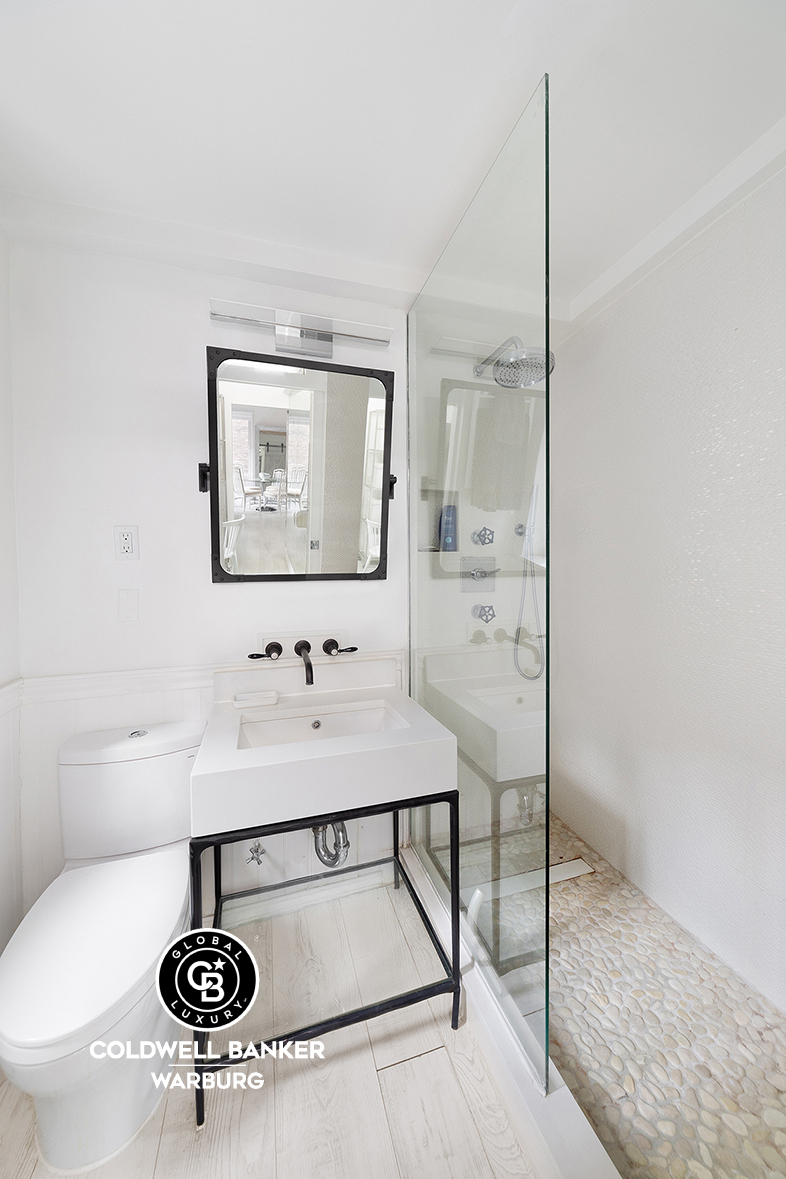 750 Park Avenue, Unit 16D Manhattan, NY 10021 - Photo 6 of 7 a bathroom with a sink a light fixture and a mirror