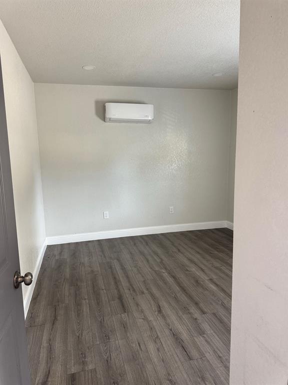 9551 Lechner Road, Unit G Fort Worth, TX 76179 - Photo 7 of 15 Spacious room featuring wood-finish flooring, light gray walls, white baseboards, a mini-split HVAC unit, and recessed ceiling lighting