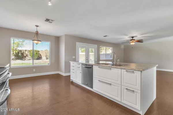 a kitchen with white cabinets and window