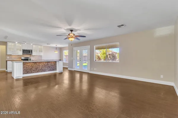 a view of an empty room with a window and wooden floor