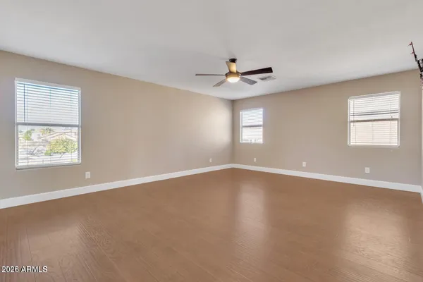 a view of an empty room with a window and wooden floor