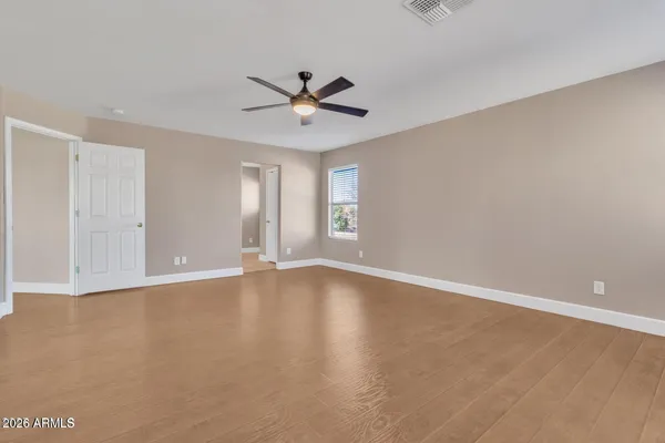 a view of an empty room with window and wooden floor